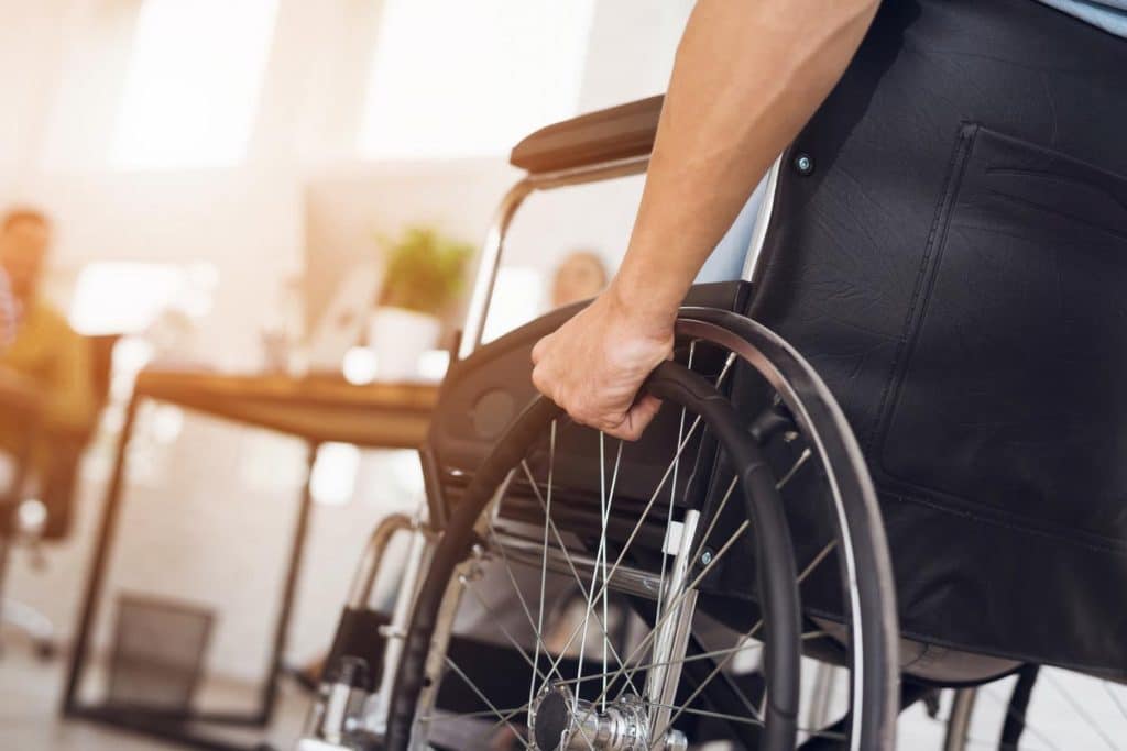 homme sur un fauteuil roulant sur son lieu de travail