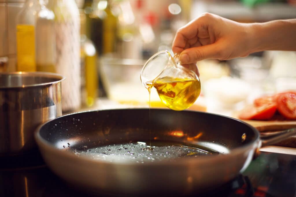 Cook Pours Oil On A Skillet