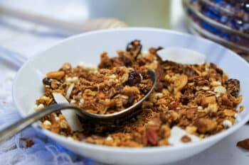 A Close Up Vigranola noix santéew Of A Bowl Filled With Granola, Displaying Its Wholesome Blend Of Oats, Nuts, Seeds, And Dried Fruits, Ready To Be Savored For A Delightful And Nutritious Meal.