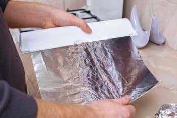 quelle face papier alu choisir Avant de répondre à la grande question, il est intéressant de comprendre pourquoi le papier aluminium possède un côté brillant et un côté mat. La différence vient tout simplement de son processus de fabrication. Lors de la production, deux feuilles d’aluminium sont superposées pour éviter qu’elles ne se déchirent lorsqu’elles passent entre les rouleaux de laminage. Le côté en contact avec les rouleaux lisses devient brillant, tandis que l’autre côté, pressé contre la seconde feuille d’aluminium, conserve un aspect mat. En réalité, cette différence est purement esthétique et ne repose sur aucune fonction délibérément ajoutée lors de la fabrication. Mais alors, est-ce que cela change quelque chose dans nos usages en cuisine ? Le côté brillant ou le côté mat : quelles différences en cuisine ? 1. Pour la cuisson au four : une nuance minime Lorsqu’il s’agit de cuire des aliments au four, le papier aluminium est souvent utilisé pour envelopper des pommes de terre, protéger une pièce de viande ou recouvrir un plat. Ici, beaucoup pensent que le côté mat retient mieux la chaleur et que le côté brillant réfléchit davantage. En pratique, la différence est infime : l’aluminium est un excellent conducteur thermique, et la chaleur est répartie de manière quasi identique des deux côtés. Toutefois, le côté brillant reflète légèrement plus les ondes de chaleur, ce qui pourrait entraîner une cuisson marginalement plus douce. Cela dit, dans la grande majorité des cas, cela n’aura pas d’impact significatif sur vos plats. À retenir : Pour la cuisson au four, vous pouvez utiliser le papier aluminium dans n’importe quel sens sans que cela ne change réellement le résultat. 2. Pour la conservation des aliments : le côté brillant est privilégié Lorsqu’il s’agit de conserver des aliments, en particulier au réfrigérateur, le côté brillant est souvent recommandé. Pourquoi ? Parce que sa surface réfléchissante rejette davantage la chaleur et la lumière, ce qui permet de garder les aliments au frais plus longtemps. Par exemple : Pour transporter des crudités ou des fruits, enveloppez-les avec le côté brillant vers l’extérieur. Pour des aliments chauds que vous souhaitez maintenir tièdes, vous pouvez inverser et mettre le côté mat vers l’extérieur pour mieux retenir la chaleur. À retenir : En conservation, le côté brillant est légèrement plus efficace pour garder les aliments frais. Attention aux usages déconseillés : les erreurs à éviter Si le papier aluminium est pratique, il existe toutefois quelques précautions à prendre pour éviter certains risques pour la santé ou des erreurs d’utilisation. 1. Évitez le contact avec les aliments acides L’aluminium peut réagir avec des aliments acides (comme la tomate, le citron ou les marinades) et entraîner une migration de particules d’aluminium vers les aliments. Même si les quantités sont souvent minimes, il est préférable de limiter ce contact. Solution : Dans ces cas, optez pour du papier sulfurisé ou des contenants en verre. 2. Ne mettez pas le papier aluminium au micro-ondes Le papier aluminium est un métal, ce qui le rend incompatible avec le four à micro-ondes. Il peut provoquer des étincelles et endommager votre appareil. Astuce : Si vous devez chauffer des aliments, transférez-les dans un plat adapté avant de les mettre au micro-ondes. Un geste écologique : réutilisez votre papier aluminium Saviez-vous que le papier aluminium est très énergivore à produire ? De plus, lorsqu’il est souillé par des graisses ou des résidus alimentaires, il devient difficilement recyclable. Comment l’utiliser de manière durable ? Réutilisez-le : Après utilisation, lavez délicatement le papier aluminium avec de l’eau chaude et du savon, puis laissez-le sécher. Découpez de grandes feuilles : Cela facilite le nettoyage et la réutilisation. Adoptez des alternatives durables : Pensez aux emballages réutilisables en cire d’abeille (beewraps) ou aux contenants en verre pour remplacer le papier aluminium dans certaines situations. Côté brillant ou mat : retenez l’essentiel Au final, la différence entre le côté brillant et le côté mat du papier aluminium est très légère et n’impacte que marginalement son usage. Voici ce qu’il faut retenir : Pour la cuisson, le côté utilisé n’a presque aucune importance. Pour la conservation au frais, privilégiez le côté brillant pour mieux réfléchir la chaleur. Adoptez de bons réflexes pour limiter le contact avec les aliments acides et pour réutiliser le papier aluminium de façon écologique. Le papier aluminium reste un outil précieux en cuisine, mais son utilisation doit être réfléchie pour préserver à la fois votre santé et l’environnement. Alors, côté brillant ou côté mat ? Vous avez désormais toutes les clés pour ne plus jamais vous poser la question !