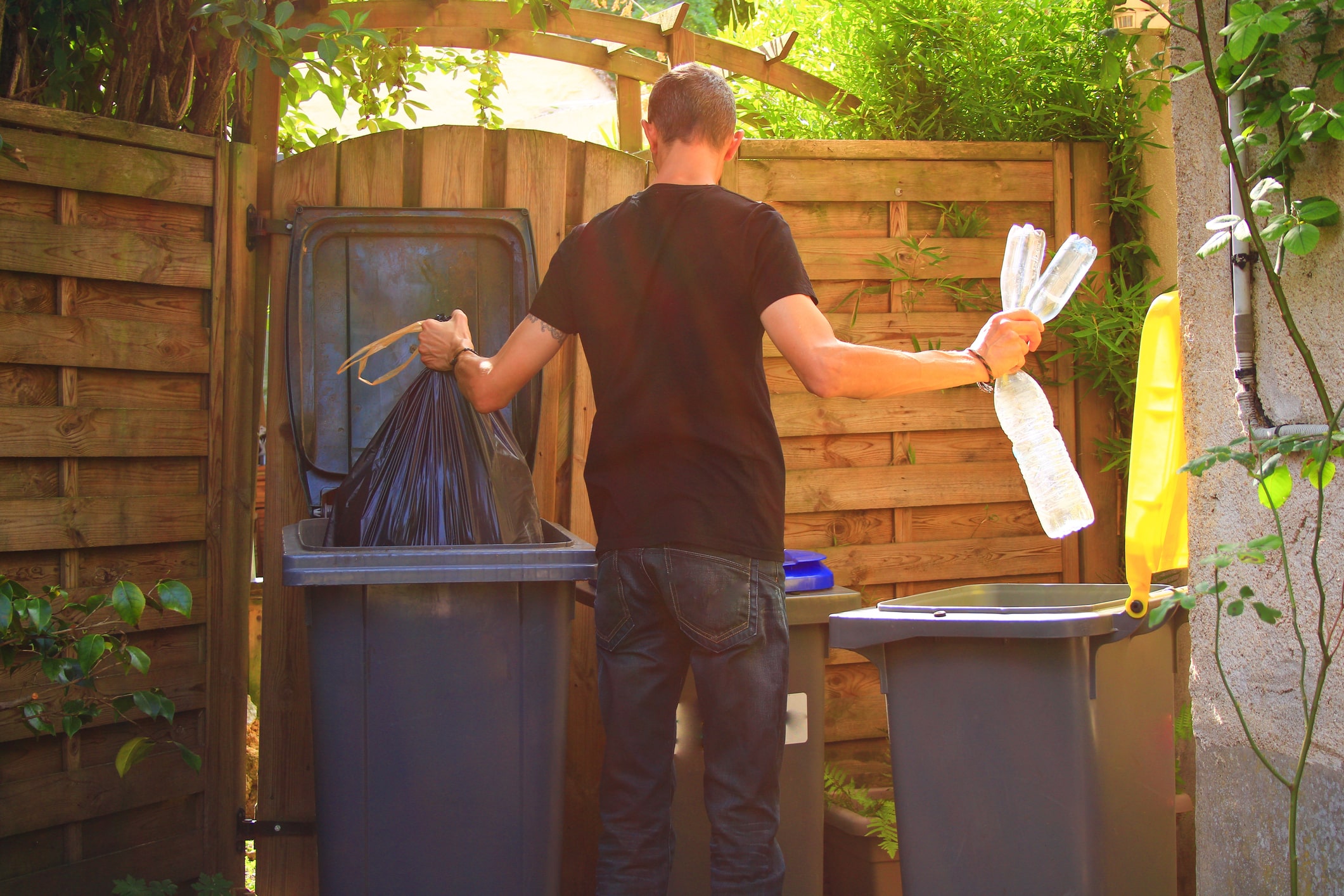 Person Performing A Selective Sorting Of Household Waste In Recycling Bins.