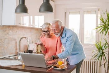 Senior Couple On Skype With Grandchildrens